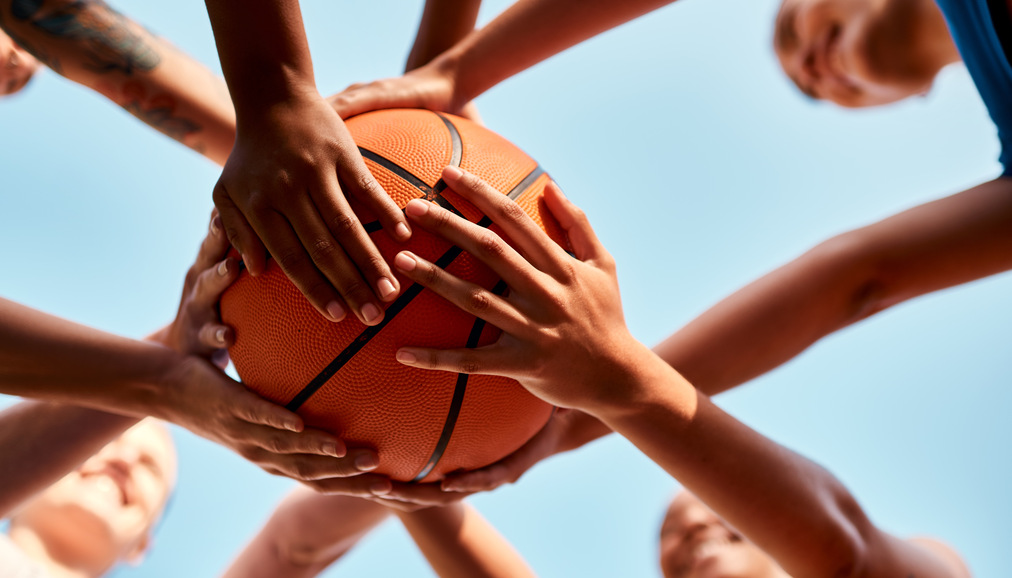 A basketball team holding the ball