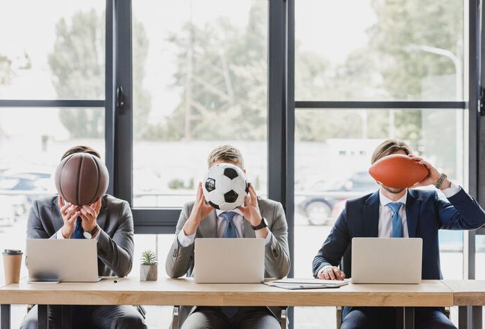 Sport marketing - men in suit sitting in office holding balls
