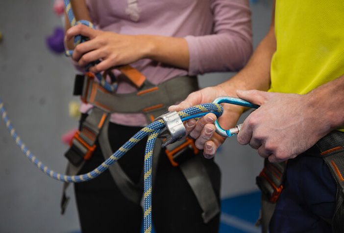 top ropes in gym - men getting ready for climbing